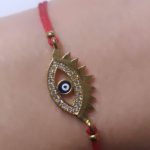 Ojo turco latón baño oro cristal austríaco.