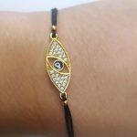 Ojo turco latón baño oro cristal austríaco negra.
