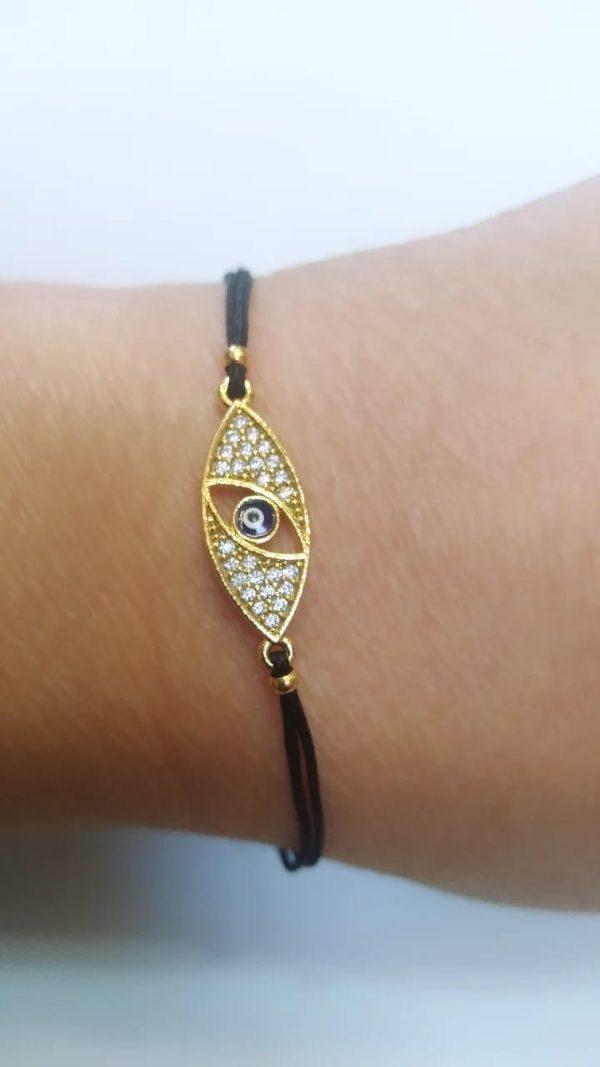 Ojo turco latón baño oro cristal austríaco negra.